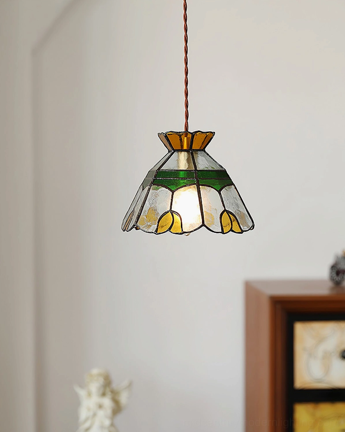 Vitral stained glass pendant light in entryway corner with wooden cabinet and table sculpture