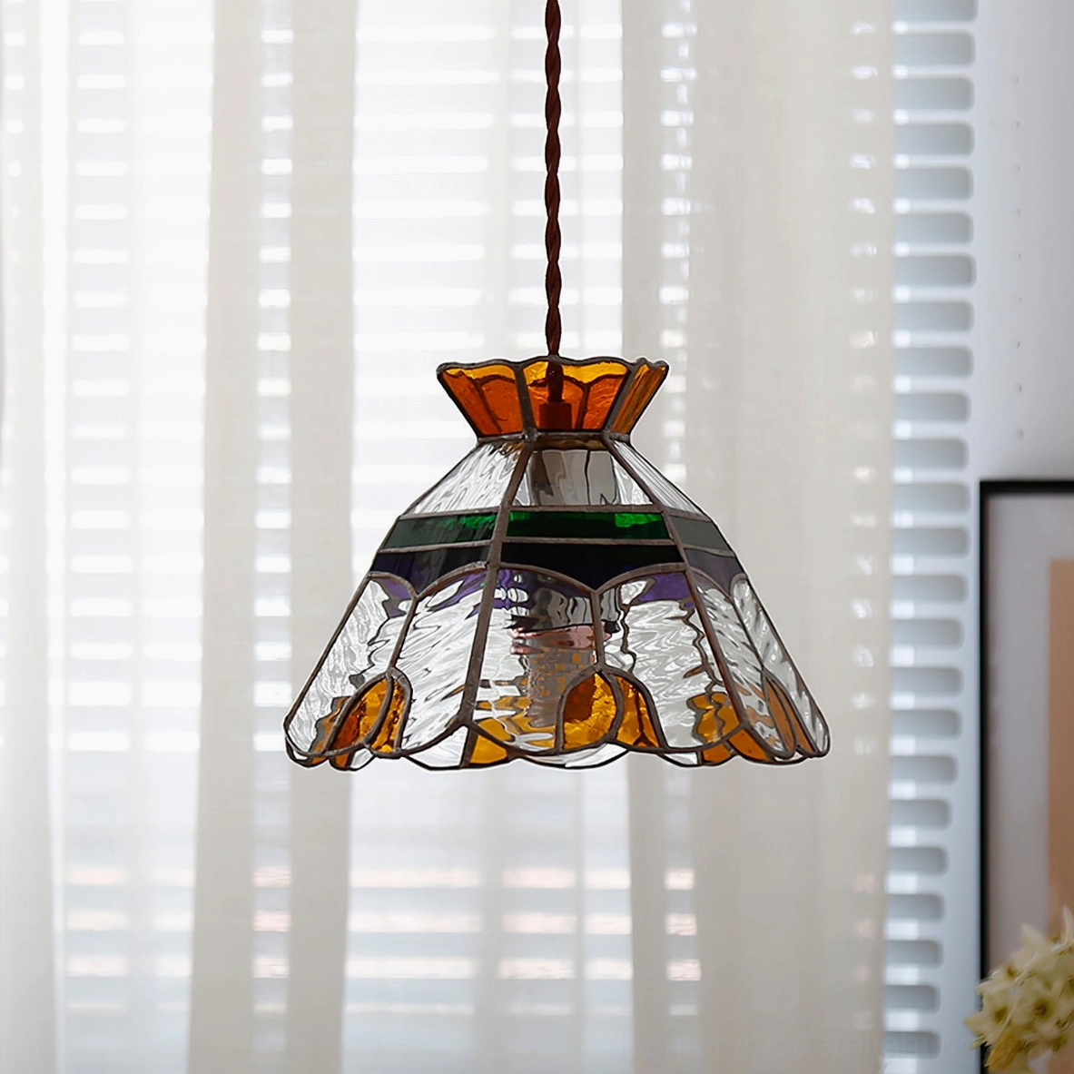 Vitral pendant lamp illuminated showing warm light through colored glass and smooth pattern design
