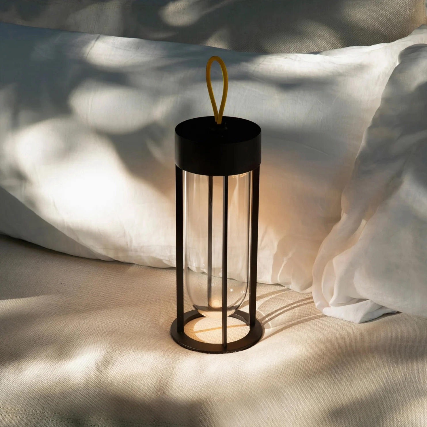 Portable Vitro LED lantern lamp on bedroom bedding creating warm ambient lighting atmosphere