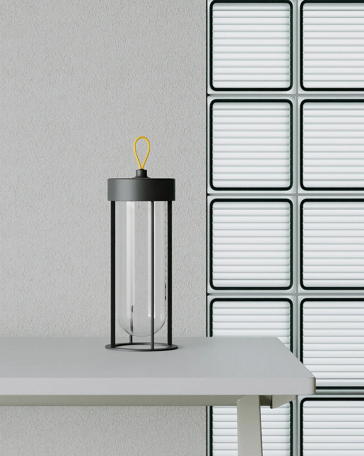 Sleek matte black Vitro minimalist table lantern against louvered wall panels