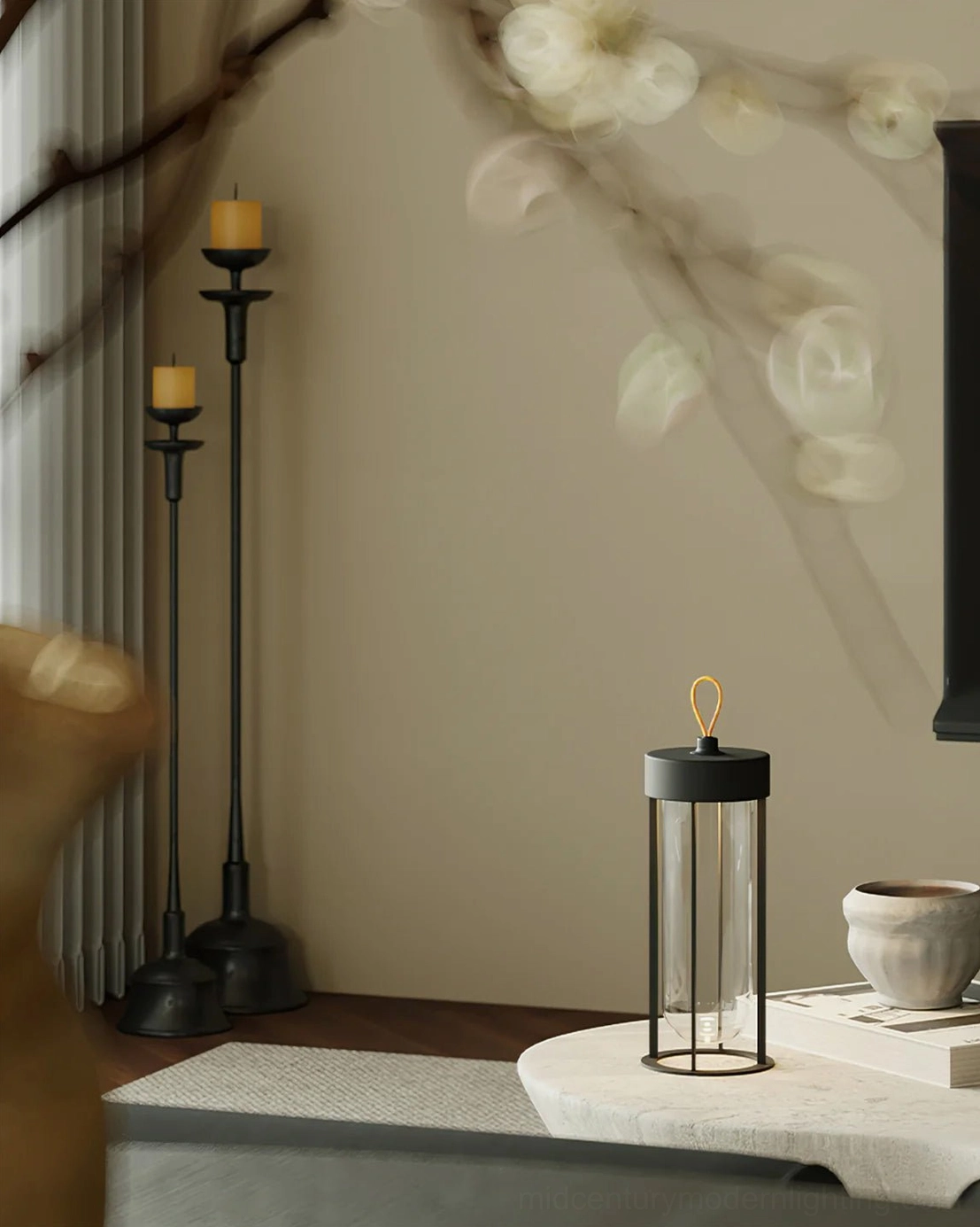 Modern Vitro portable lantern lamp paired with black candle holders in minimalist interior