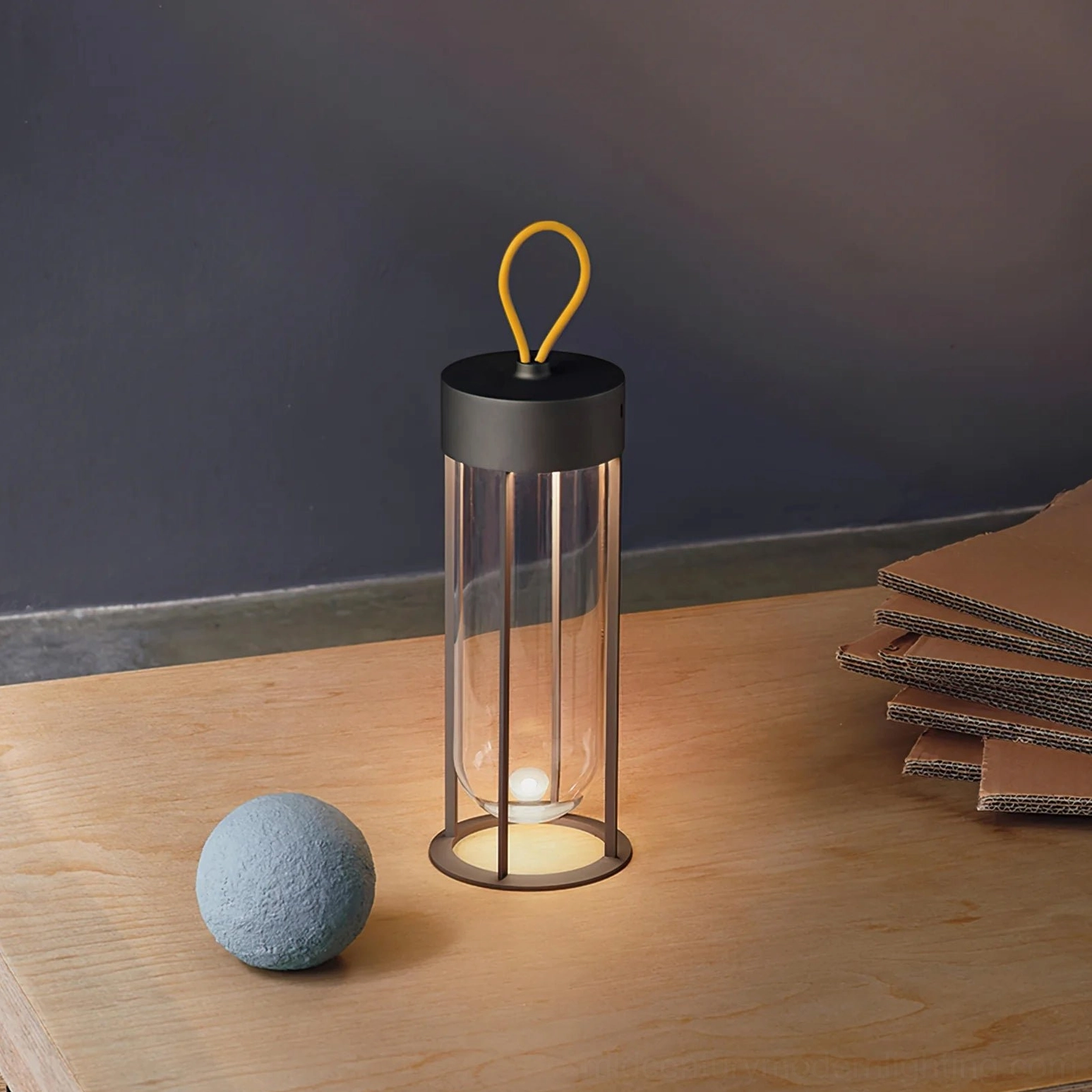Minimalist Vitro table lantern with decorative stones on wooden surface warm light