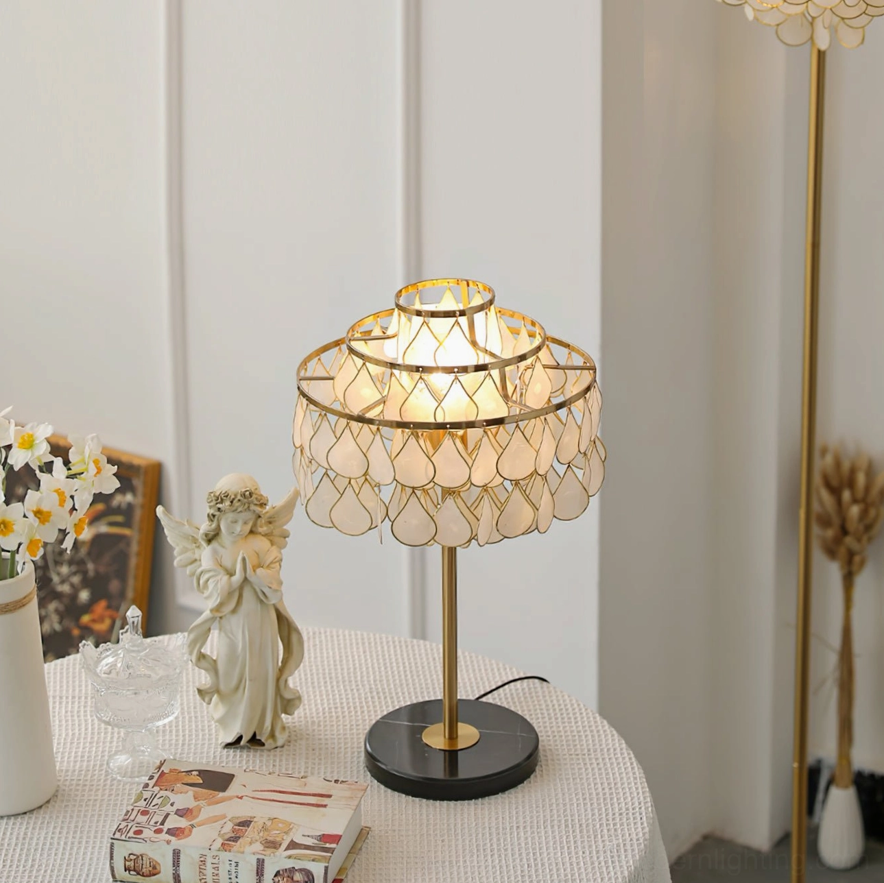 Vivant Shell Table Lamp compact two-tier version on round table with decorative figurines and magazines