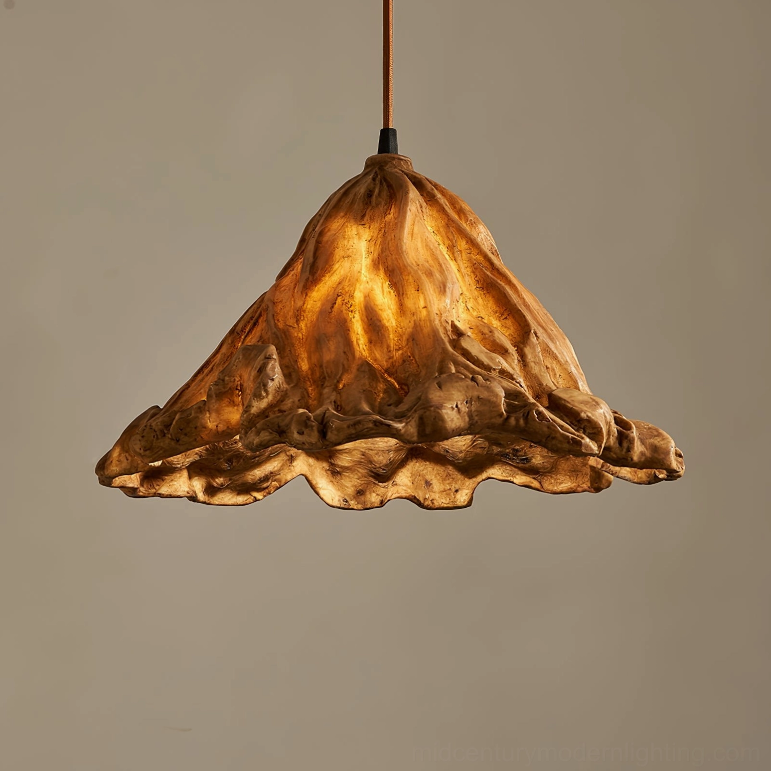 Close-up low angle view of Volcano pendant lamp showcasing irregular organic silhouette and warm interior lighting