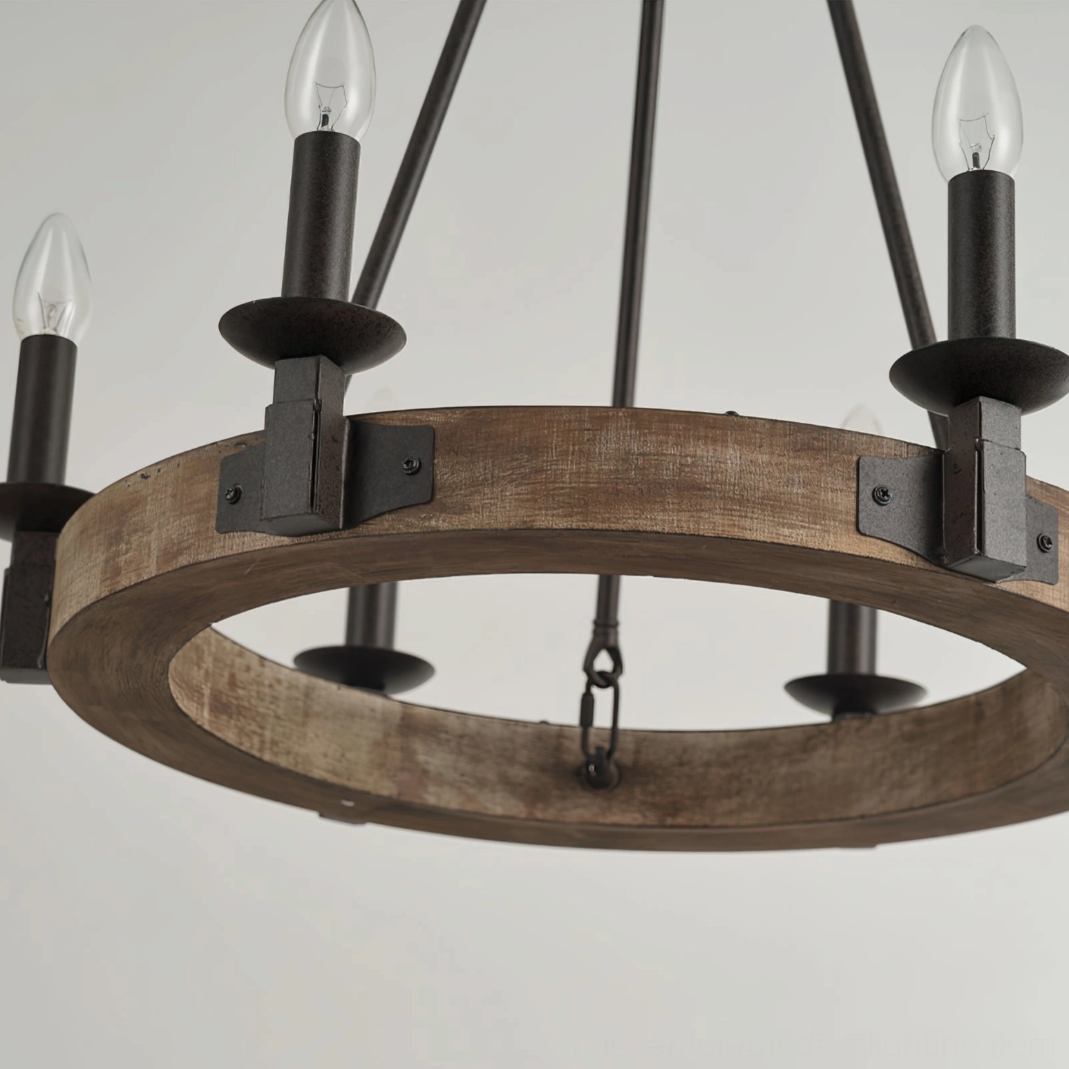 Close-up low-angle view of wagon wheel chandelier undersection showing exposed metal joinery and wooden ring craftsmanship detail