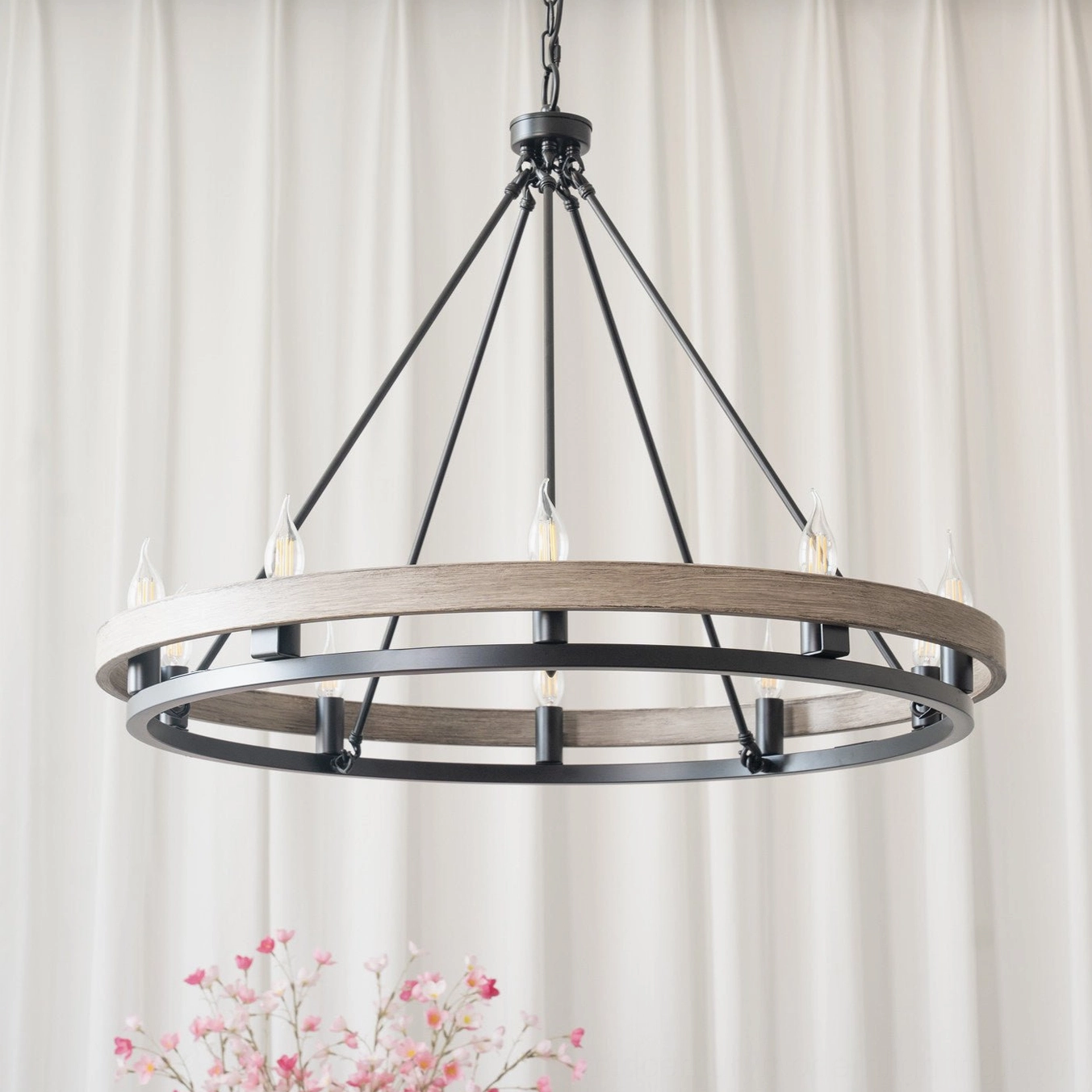 Unlit matte black wagon wheel chandelier with 10 bulb sockets showing pure metal construction without wood accents in elegant interior setting