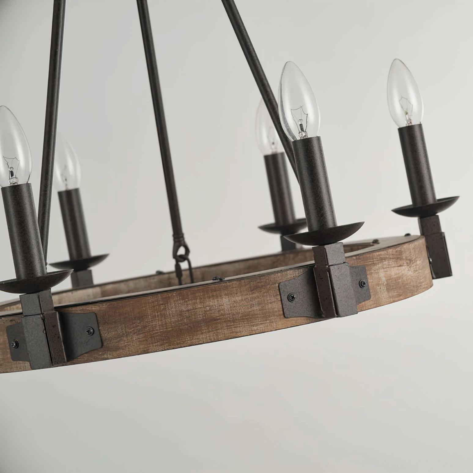 Side detail view of wagon wheel chandelier showing five visible candle bulbs and metal mounting bracket hardware against white background
