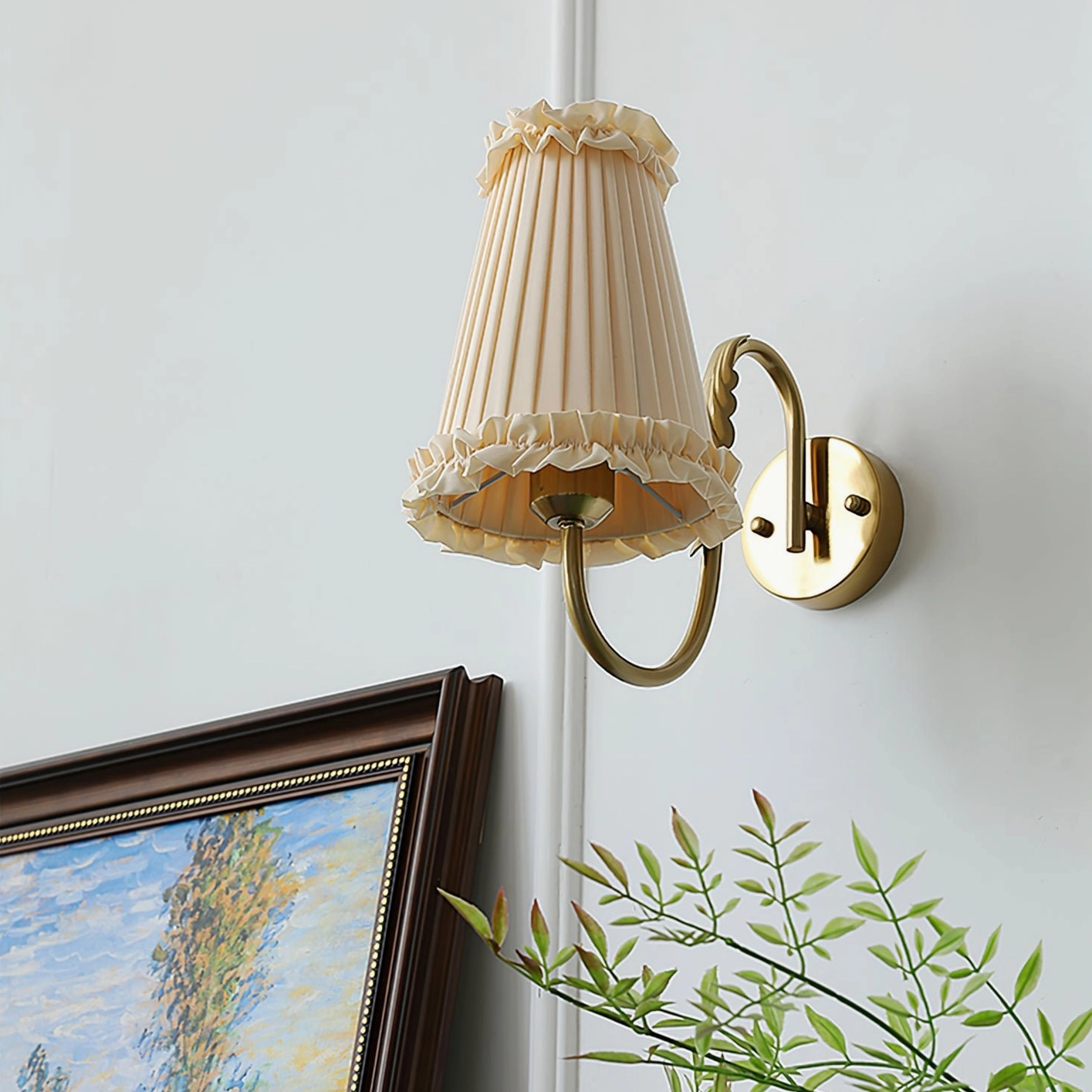 Single wall sconce fixture mounted above framed artwork with warm illumination and elegant brass finish