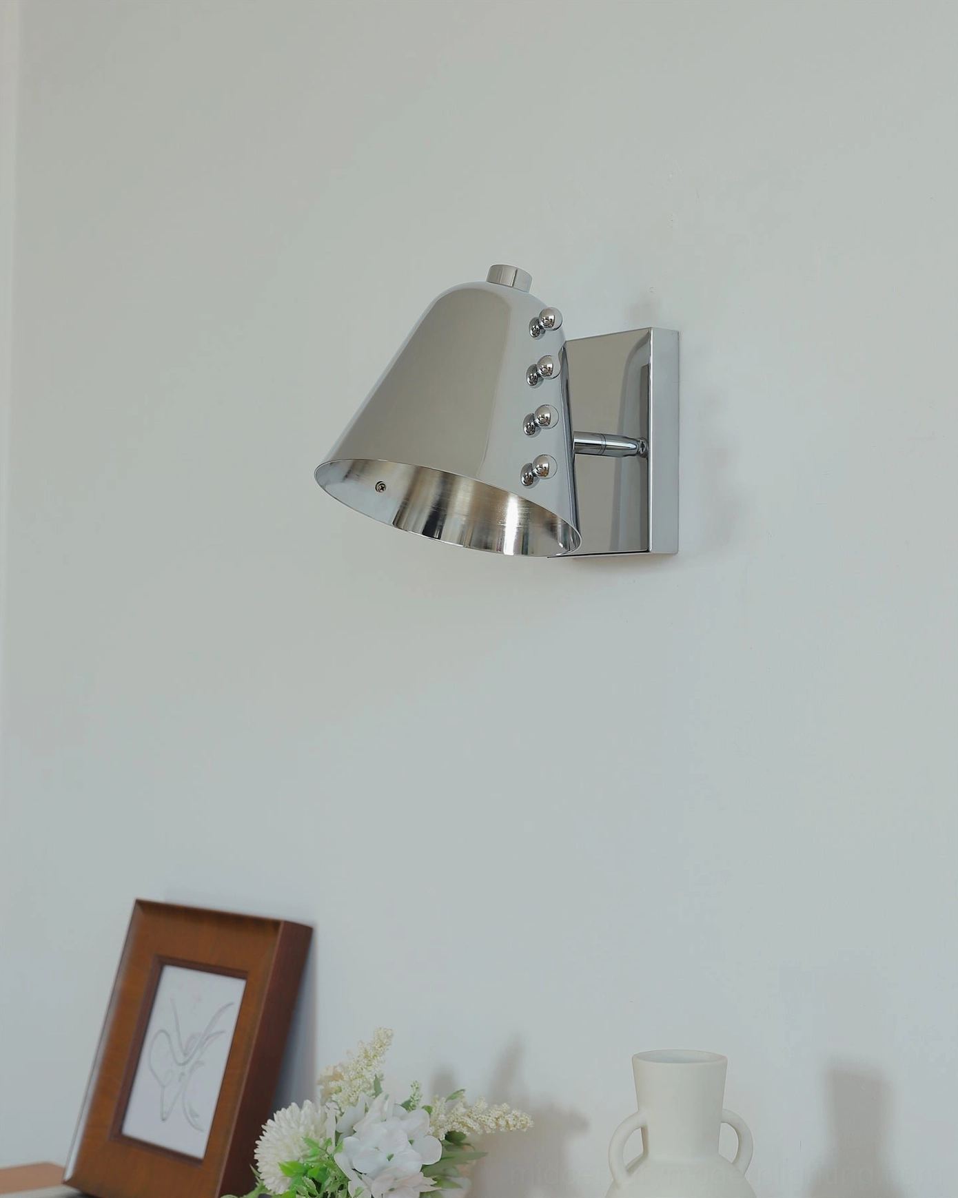 Contemporary wall sconce in modern hallway creating dramatic shadow play and architectural interest