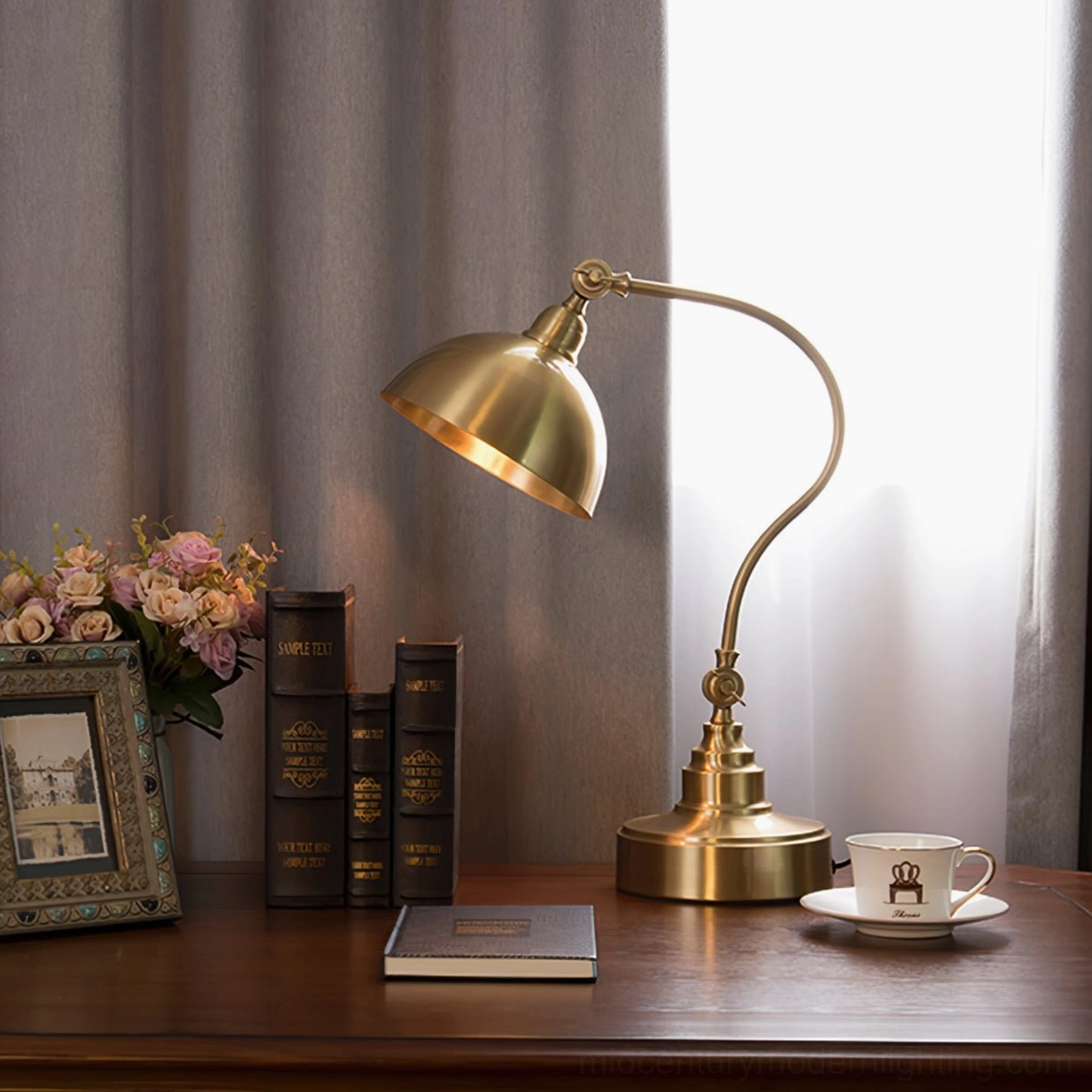 Wallace brass desk lamp styled on study desk with books and floral accessories, side profile