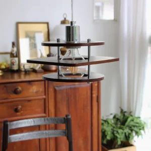 Vintage walnut pendant light with three-tier wood shades and exposed Edison bulb, dining room interior setting