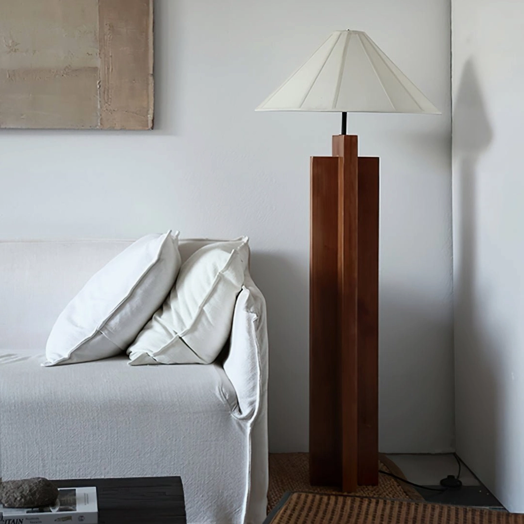 Dark walnut wood floor lamp positioned in modern living room beside linen sofa and wall art
