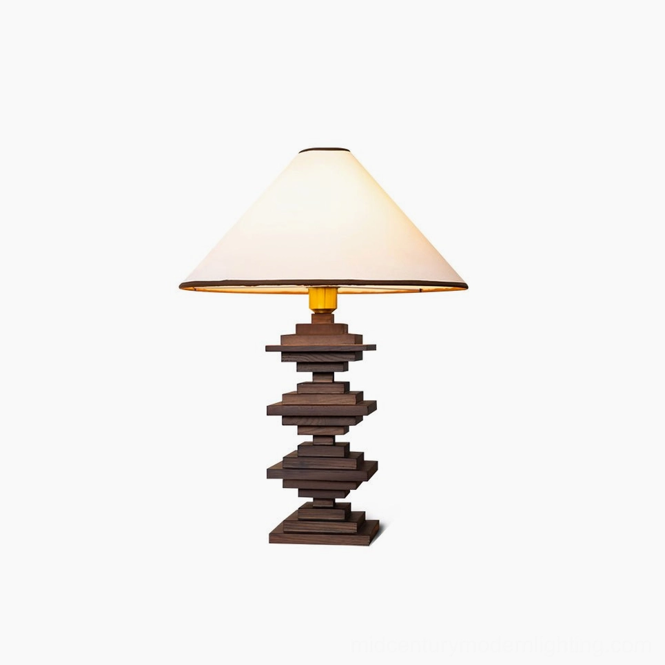 Walnut stacked wood tower table lamp with cream fabric shade and gold trim, studio white background