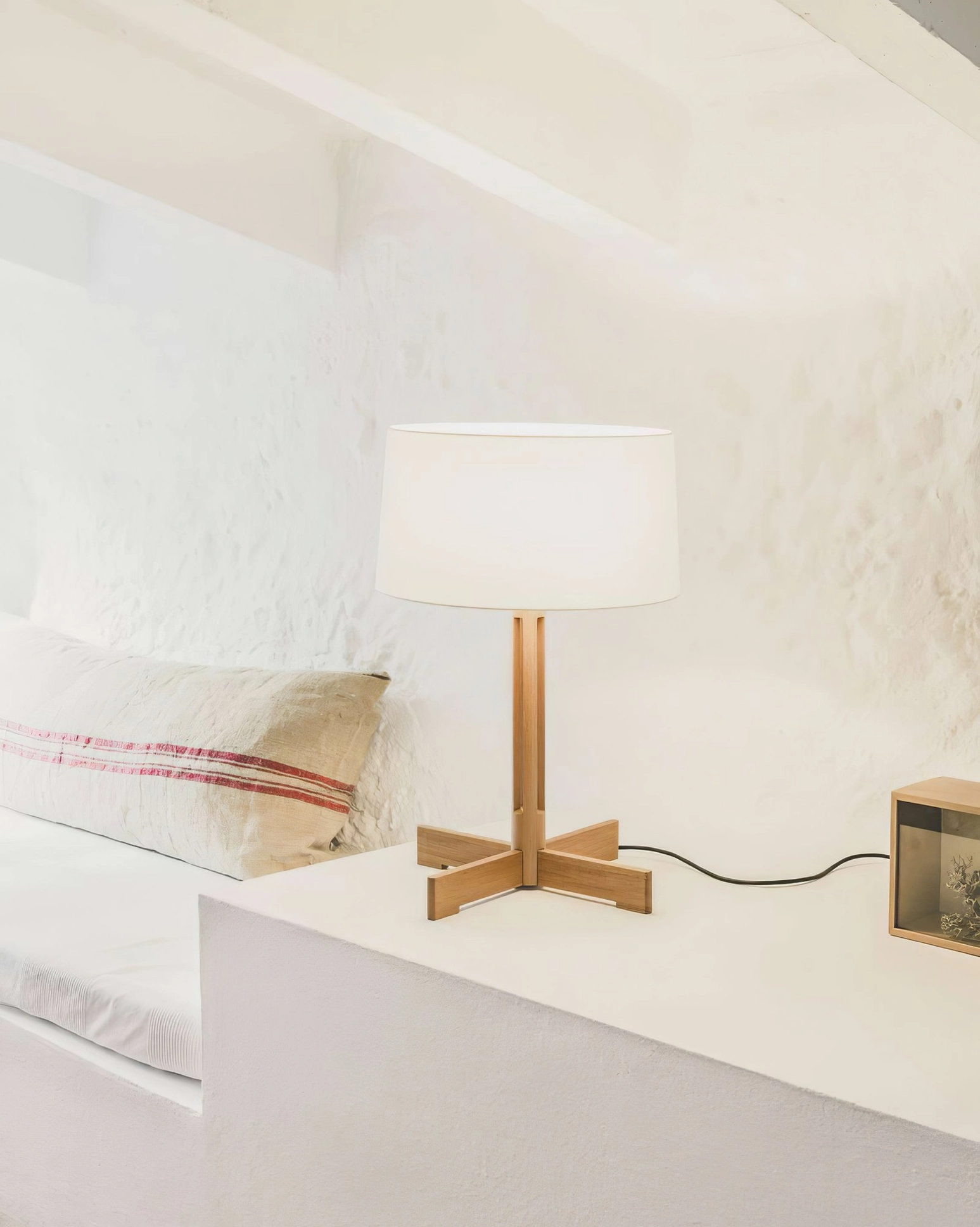 Walnut wood table lamp on modern white bedroom bedside table, natural wood grain detail