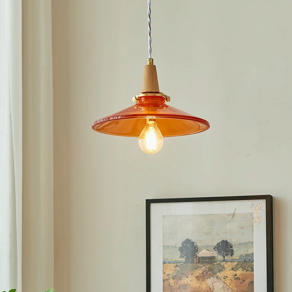 Low angle overhead view of glowing amber pendant lamp with warm bulb, sheer curtain backdrop, neutral mid-century interior - intimate ambiance