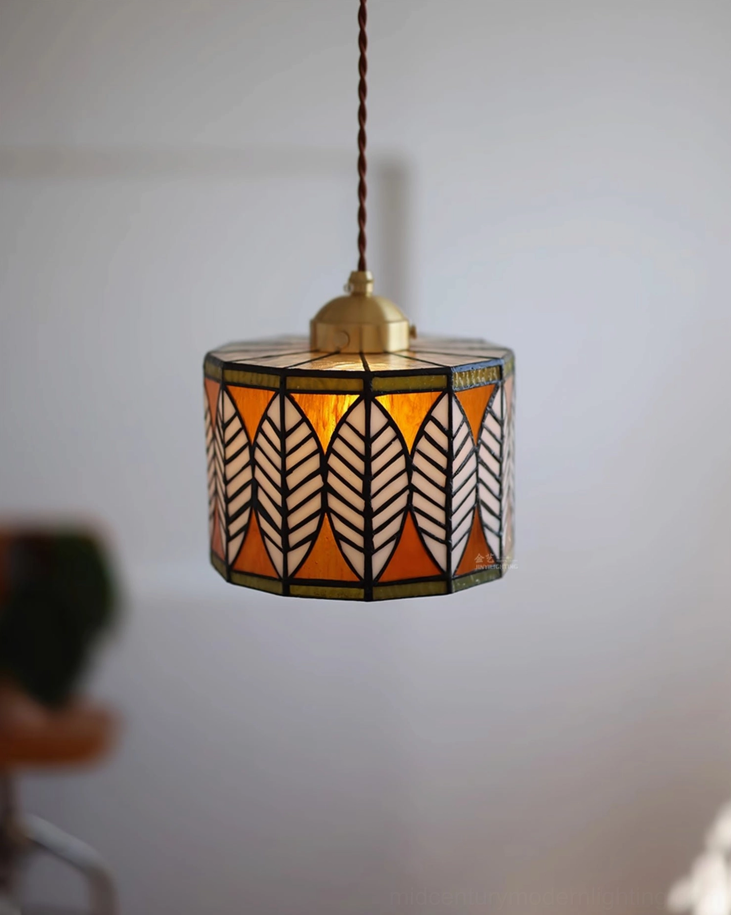 Warm-toned stained glass leaf Tiffany pendant with brass hardware, interior pendant lighting