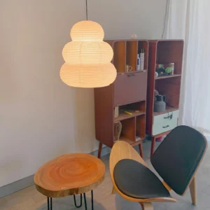 Washi 24N pendant light illuminated in mid-century modern home lounge, warm glowing ambient lighting above wooden furniture
