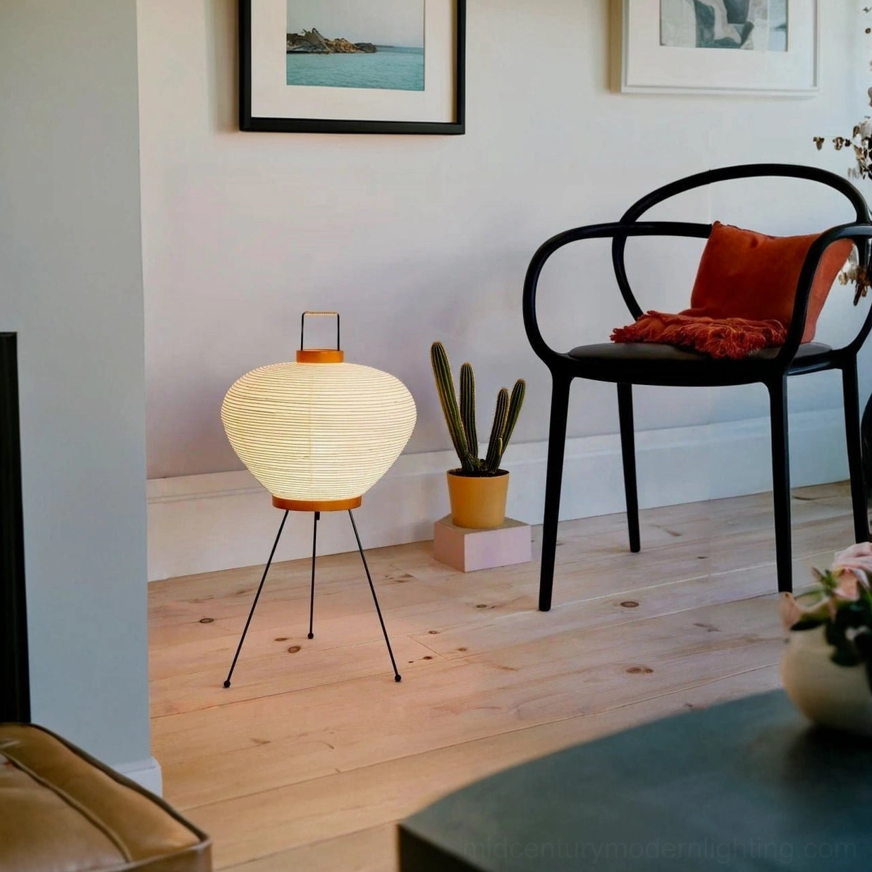 Washi paper lamp in cozy living room with accent chair and cactus plant, warm minimalist ambiance