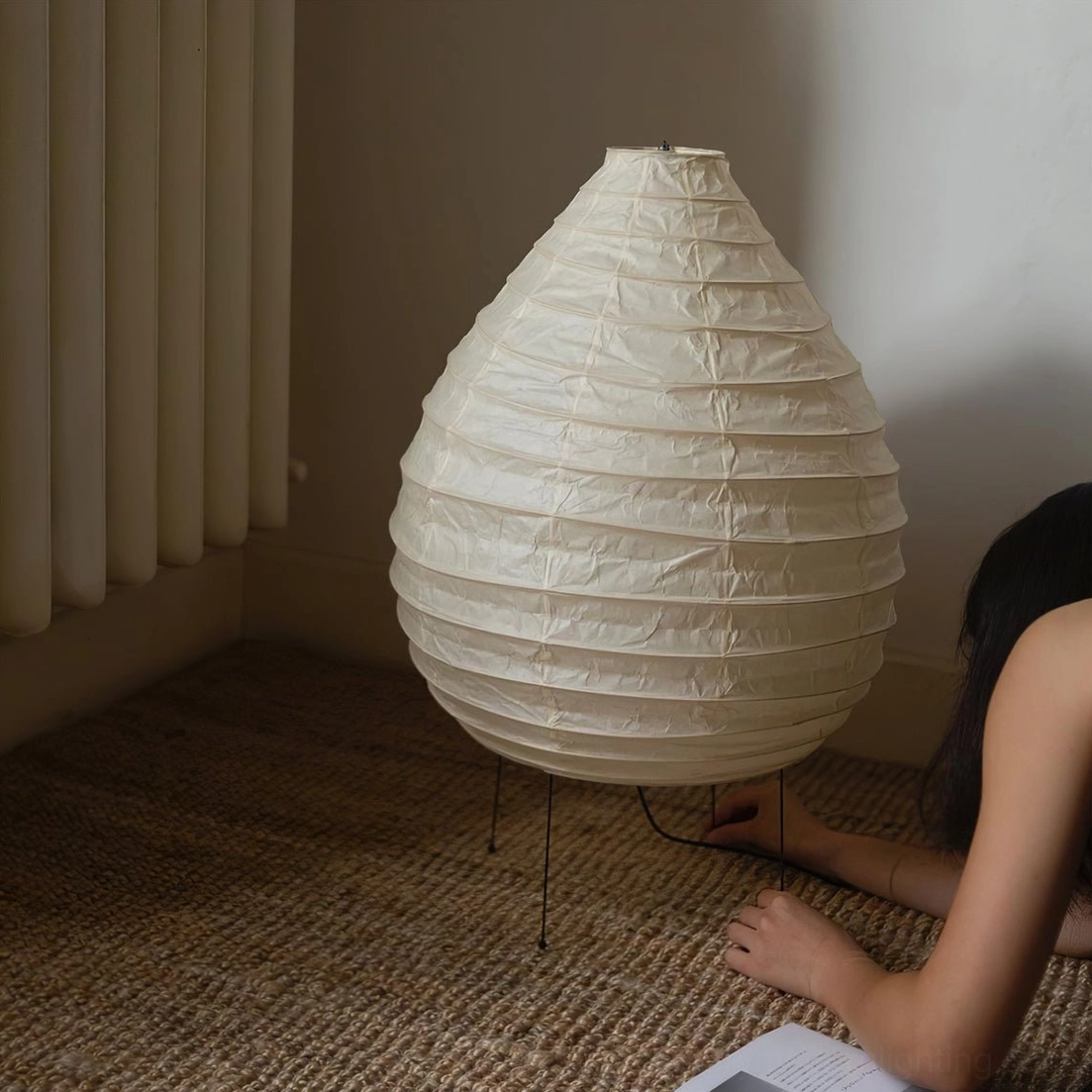 Unlit teardrop-shaped mulberry washi paper lamp on carpeted floor, sculptural form detail