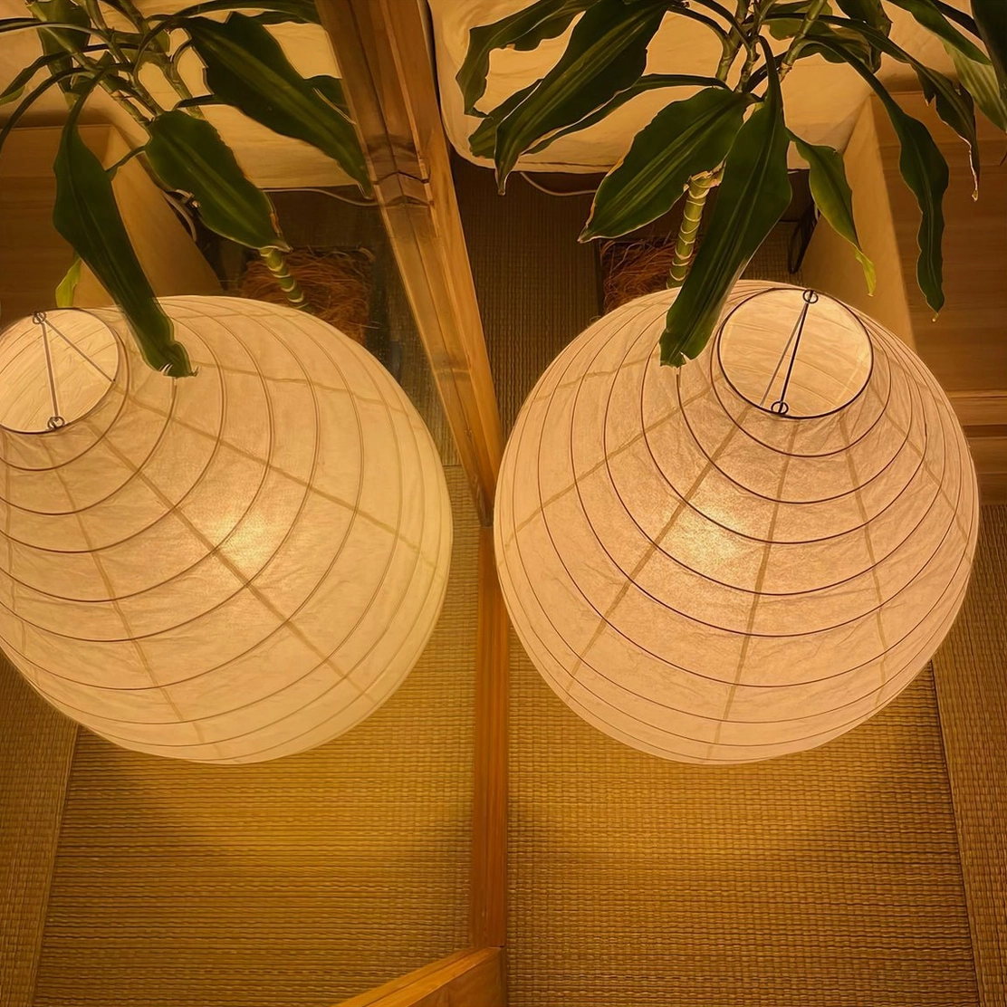 Washi paper table lamp casting warm shadows, ambient lighting atmosphere detail