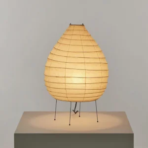 Lit washi paper table lamp glowing with warm ambient light, tabletop display on pedestal