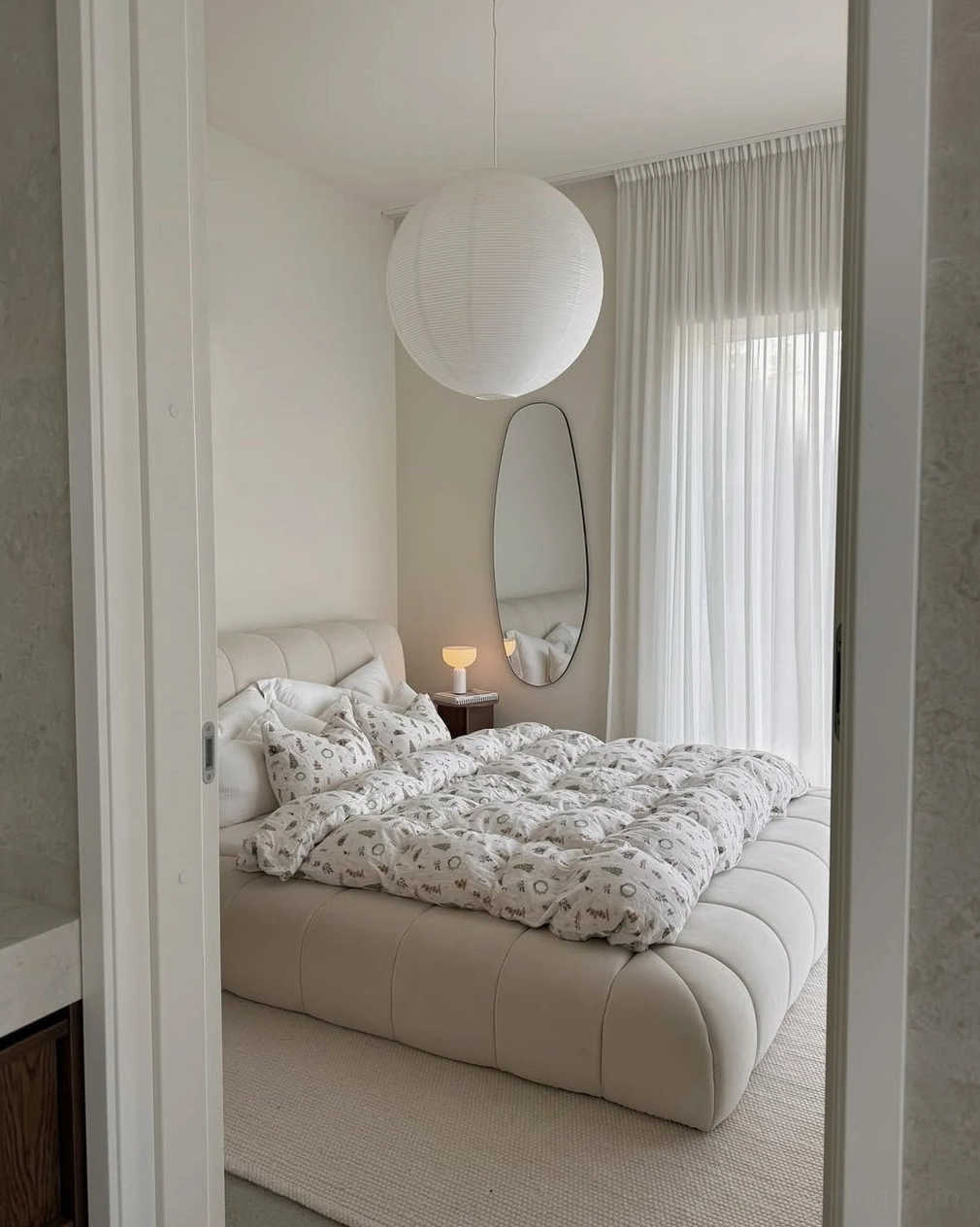 Soft white washi paper sphere pendant light in cozy minimalist bedroom, warm diffused ambient glow