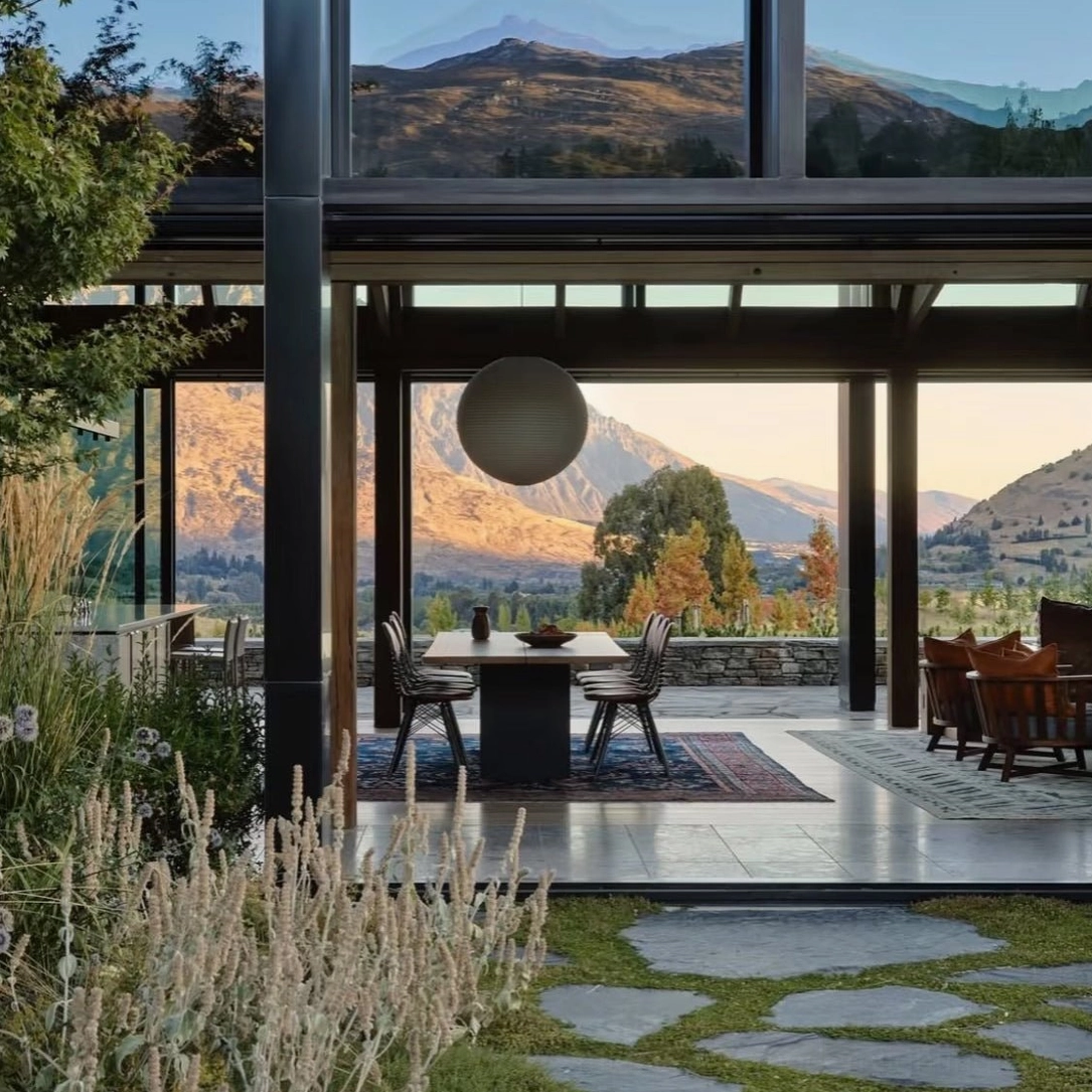 Dark gray washi paper sphere pendant lamp hanging above luxury mountain-view villa patio, modern minimalist outdoor setting