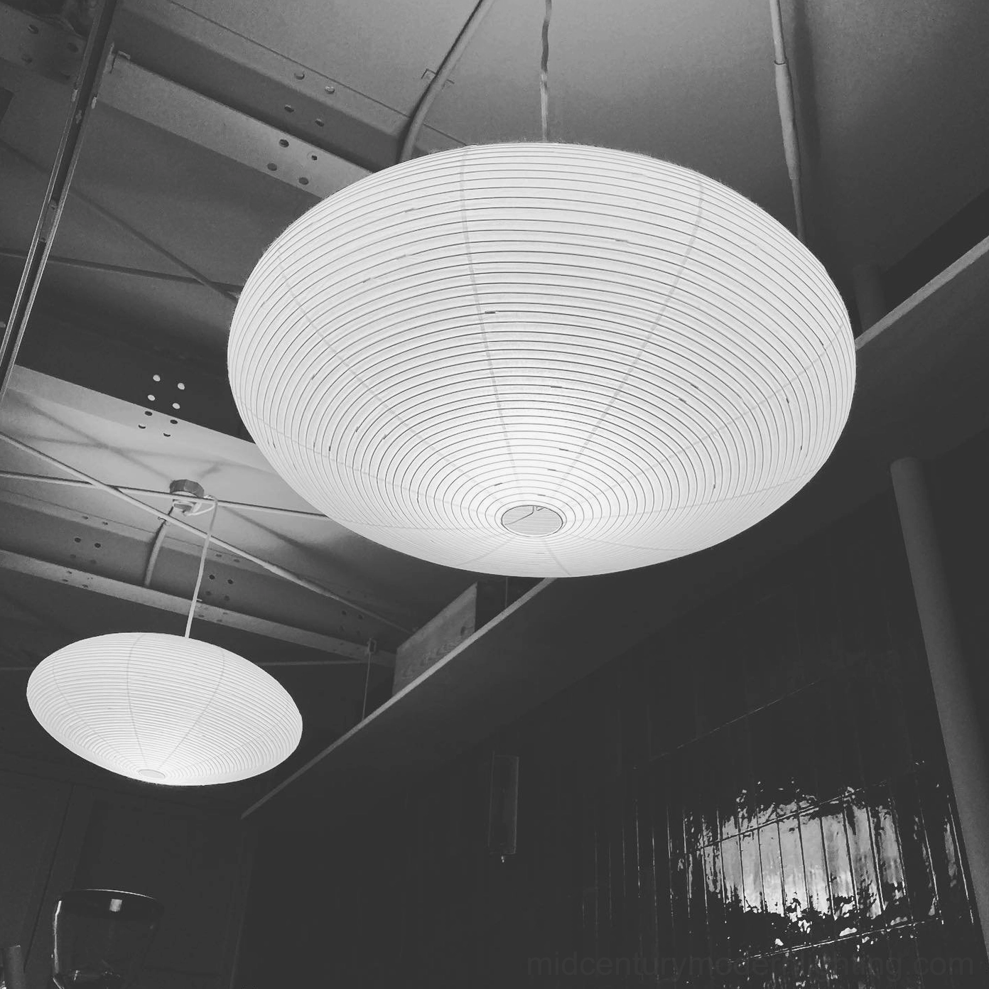 Washi paper pendant in contemporary living room with neutral textiles and warm mood lighting