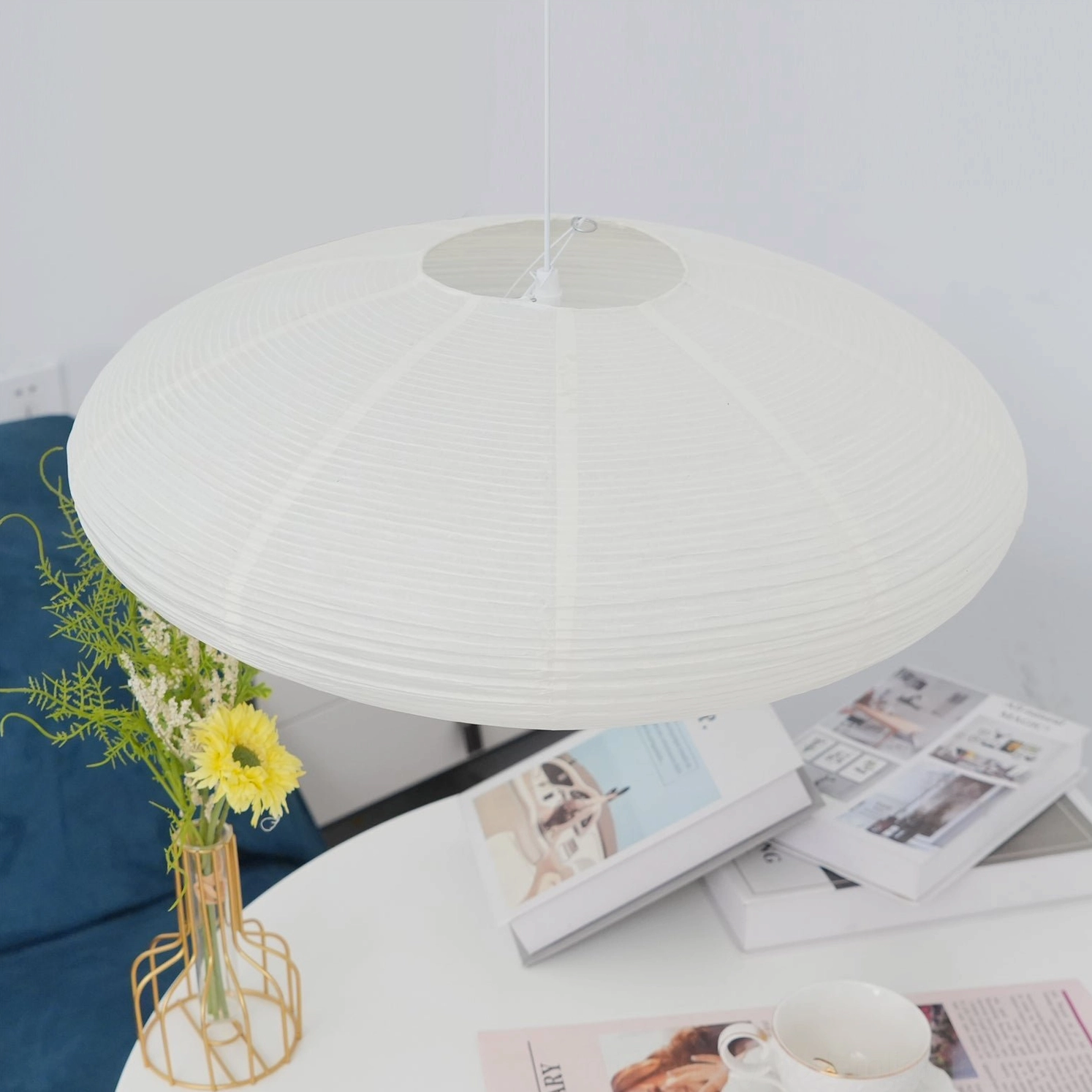 Washi pendant light suspended above wooden dining surface creating intimate warm ambiance for gatherings