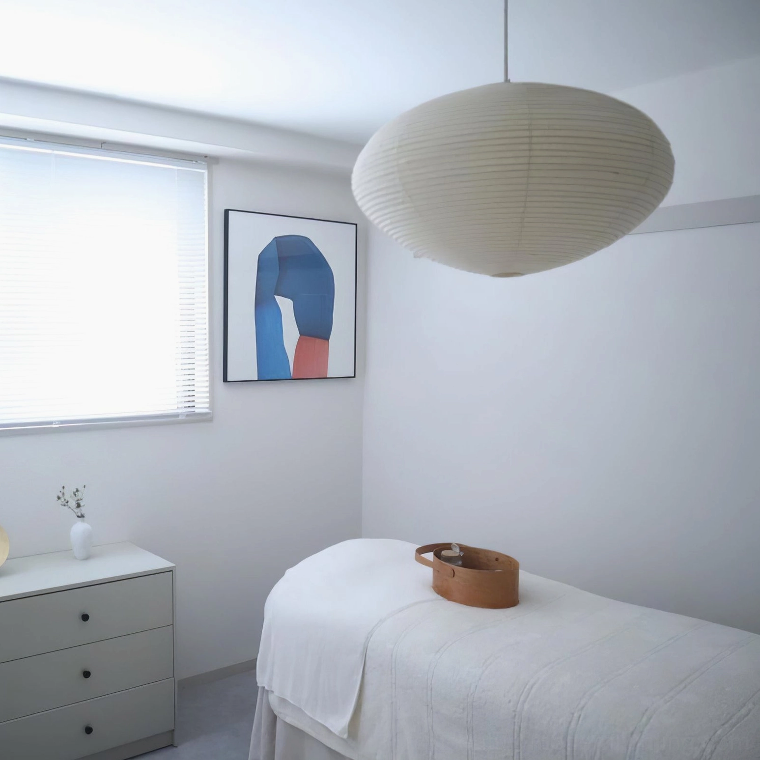 Washi pendant light in minimalist bedroom creating calm serene atmosphere with diffused warm illumination