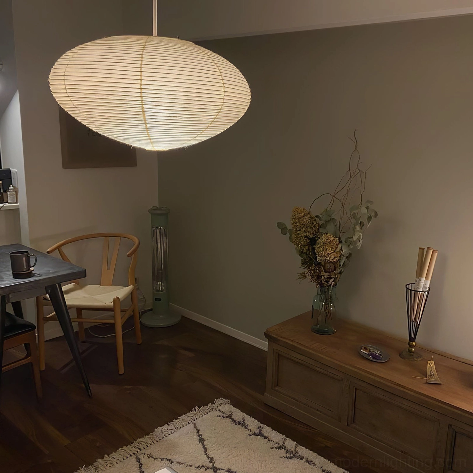 Side view of washi pendant light in cozy residential interior with wooden furniture and natural warm tones