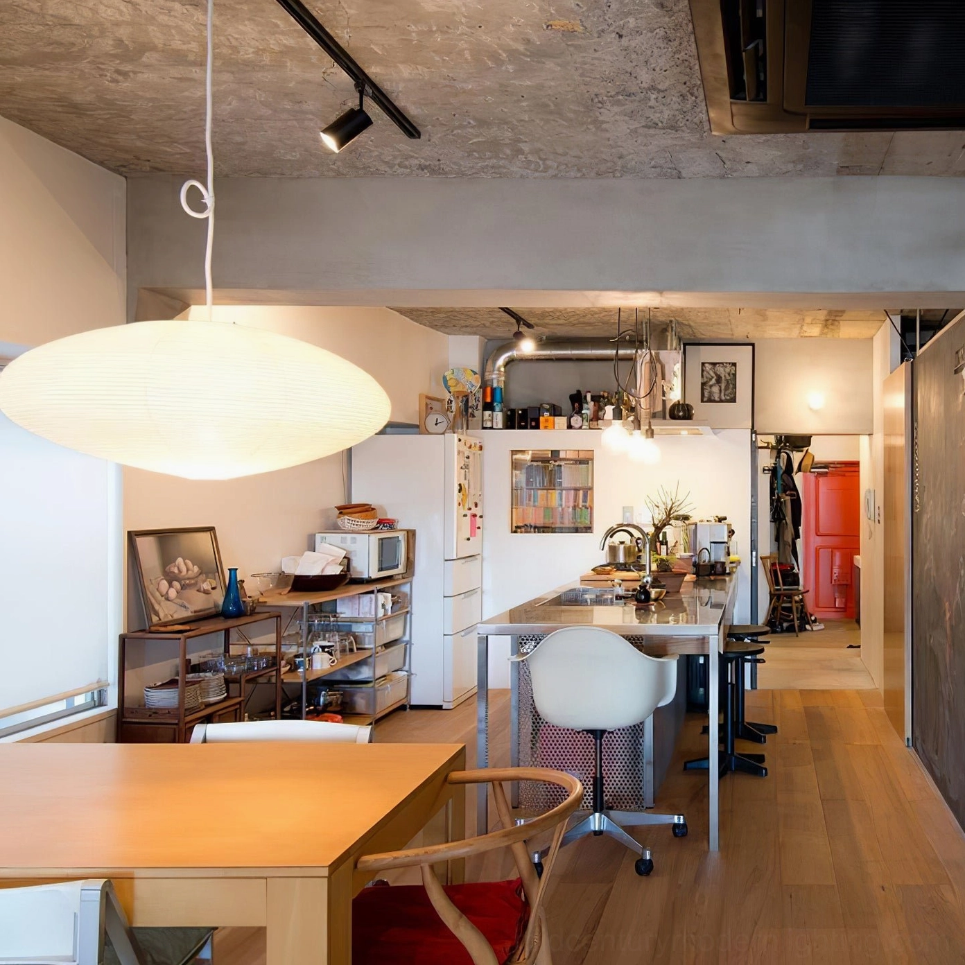 Mid-century modern interior with washi paper pendant light complementing eames-era furniture and teak accents