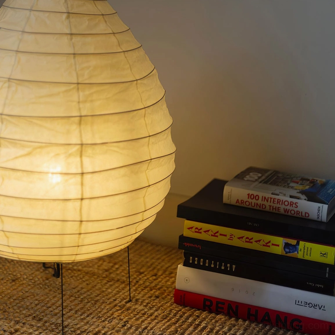 Glowing washi paper lamp in cozy reading corner with stacked books and warm ambient light