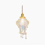 Water droplets resin pendant light hanging against white background, showcasing drip pattern and brass crown detail