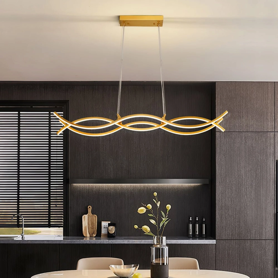 Brushed gold wave pendant lighting above dark wood dining table in contemporary kitchen with ambient warm light