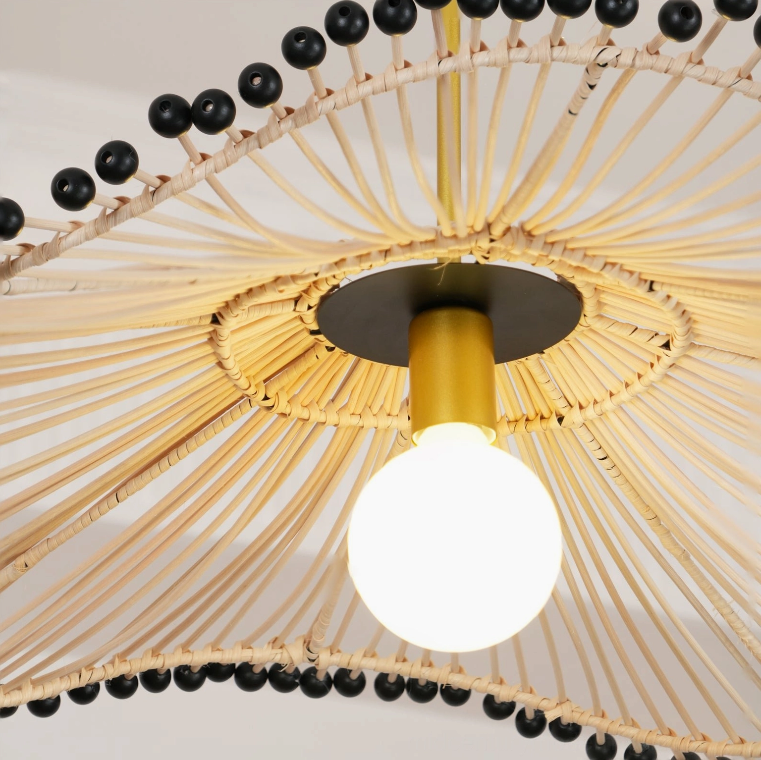 Close-up detail of handwoven rattan pendant light showing intricate weave structure and frosted glass bulb