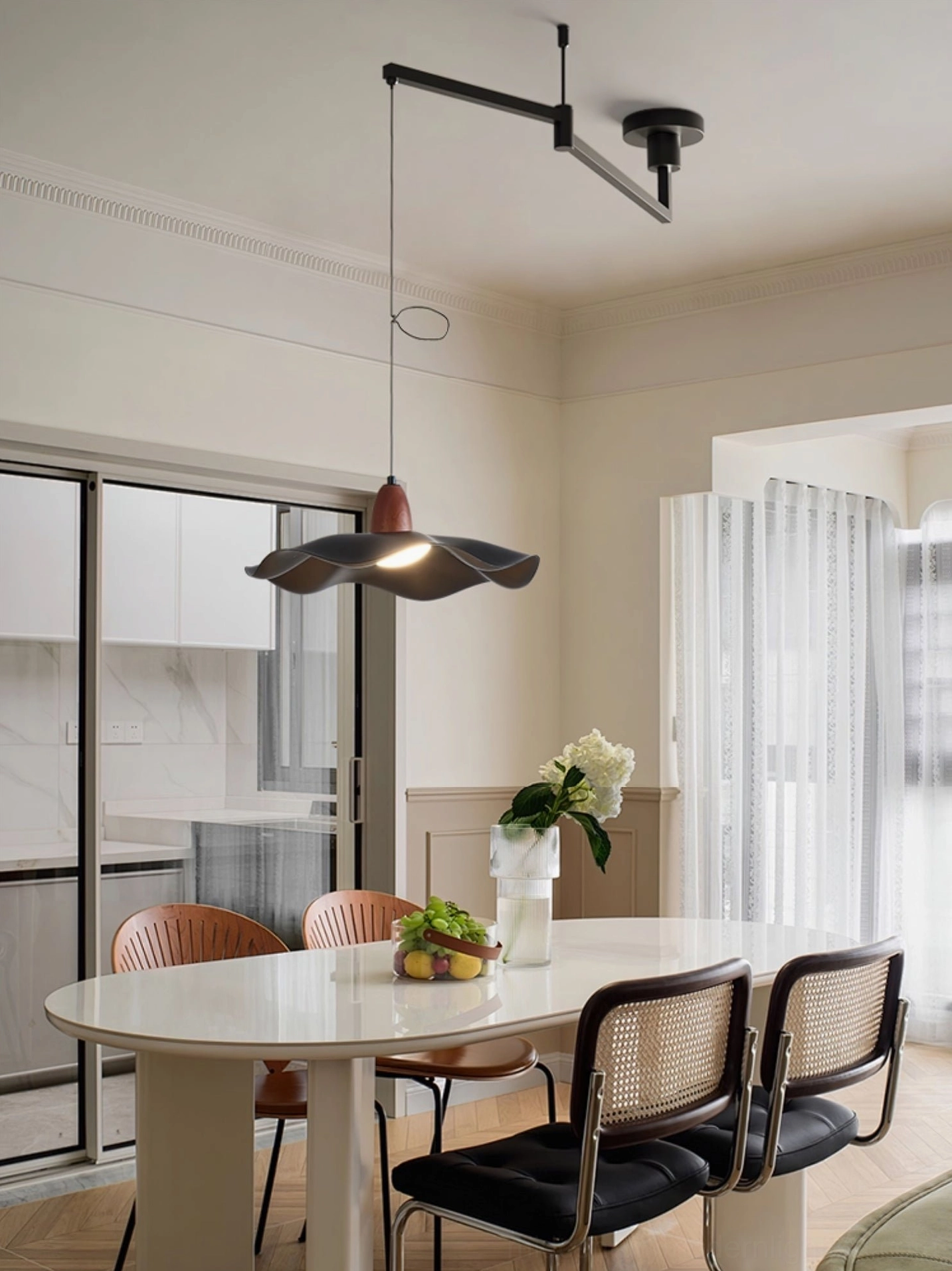 Swing arm pendant fixture above dining table in neutral modern interior with built-in display cabinetry