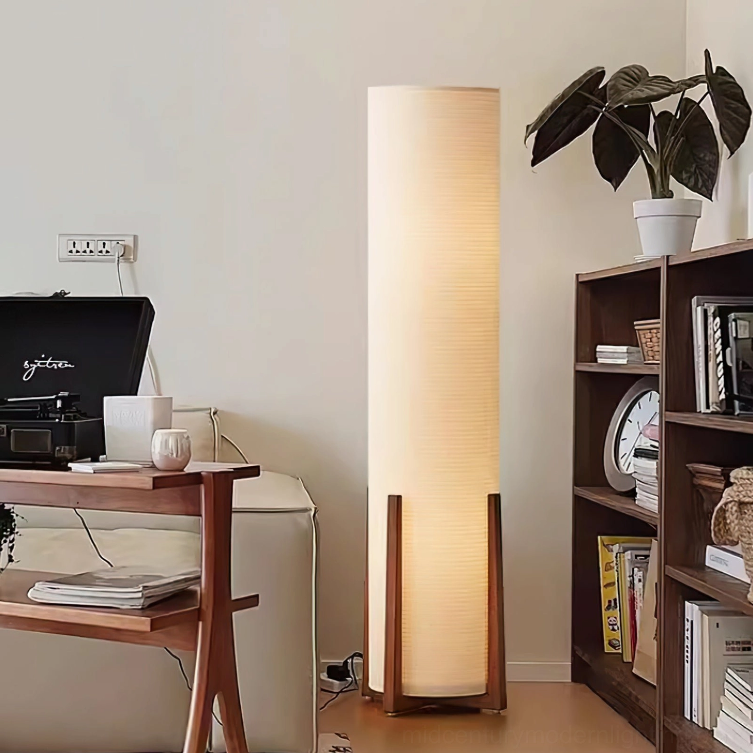 Weave Natural floor lamp styled in minimalist home setting with bookshelf and potted plant on side table