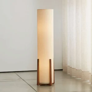 Weave Natural floor lamp illuminated in modern living room with concrete flooring and sheer curtains, warm ambient glow