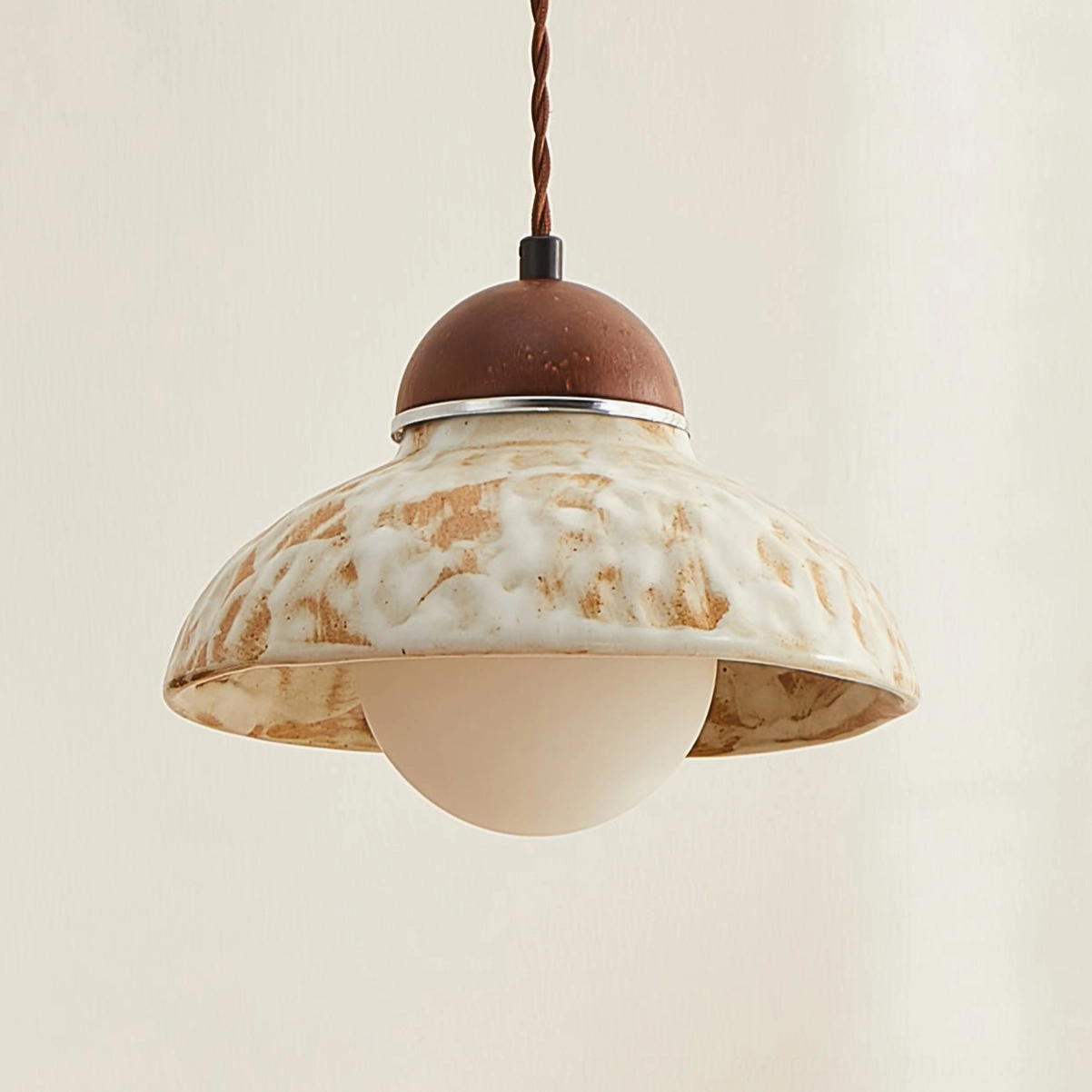 Low-angle view of Wella pendant with visible marbled ceramic glaze finish and frosted glass bulb