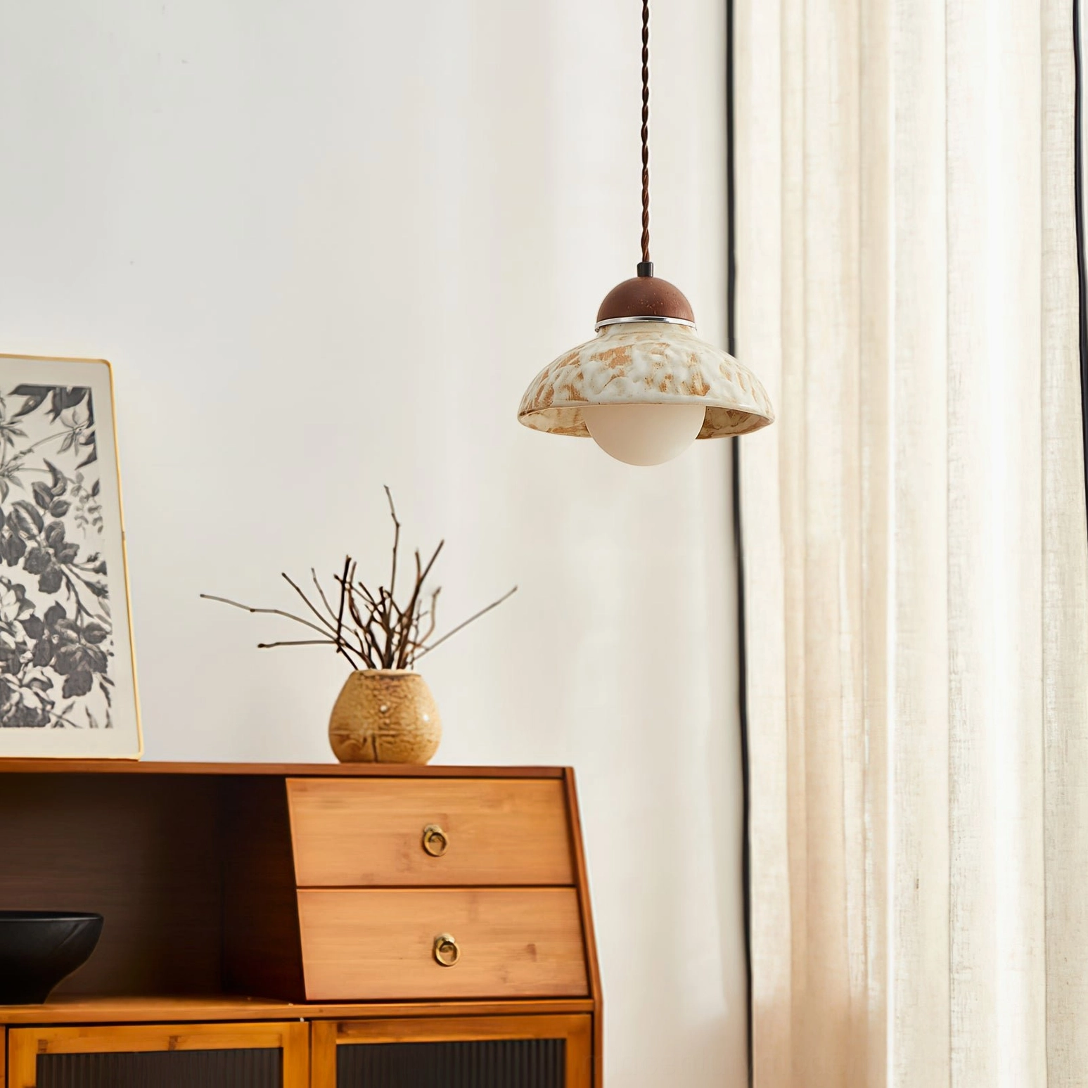 Wella dome pendant hanging above wooden cabinet with dried plant styling in mid-century modern home setting