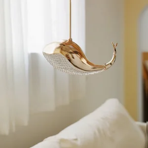 Gold whale pendant lamp hanging in bedroom with sheer curtains warm luxury lighting