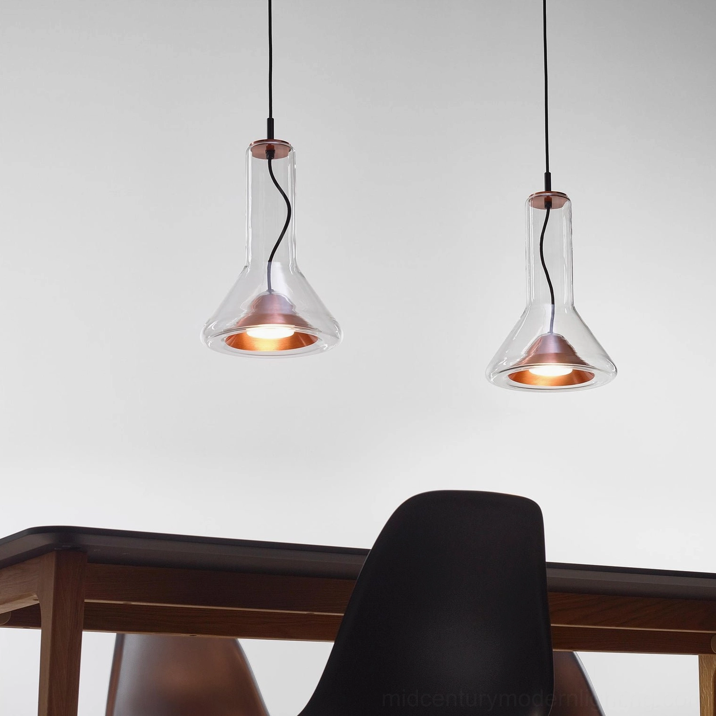 Close-up low angle view of matching glass pendant lamps, mid-century modern lighting design