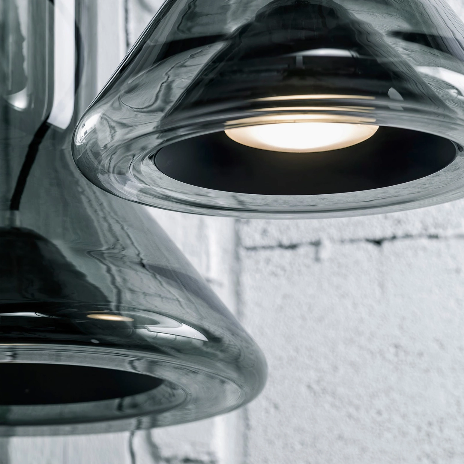 Whistle pendant lamp with integrated LED lighting against textured concrete wall, modern minimalist