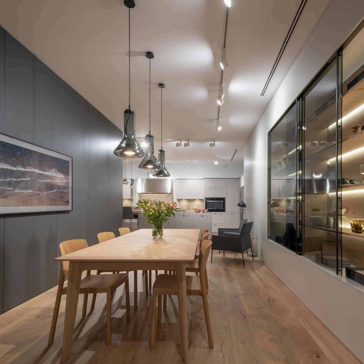 Row of whistle pendant lamps in commercial dining lounge with warm minimalist lighting design