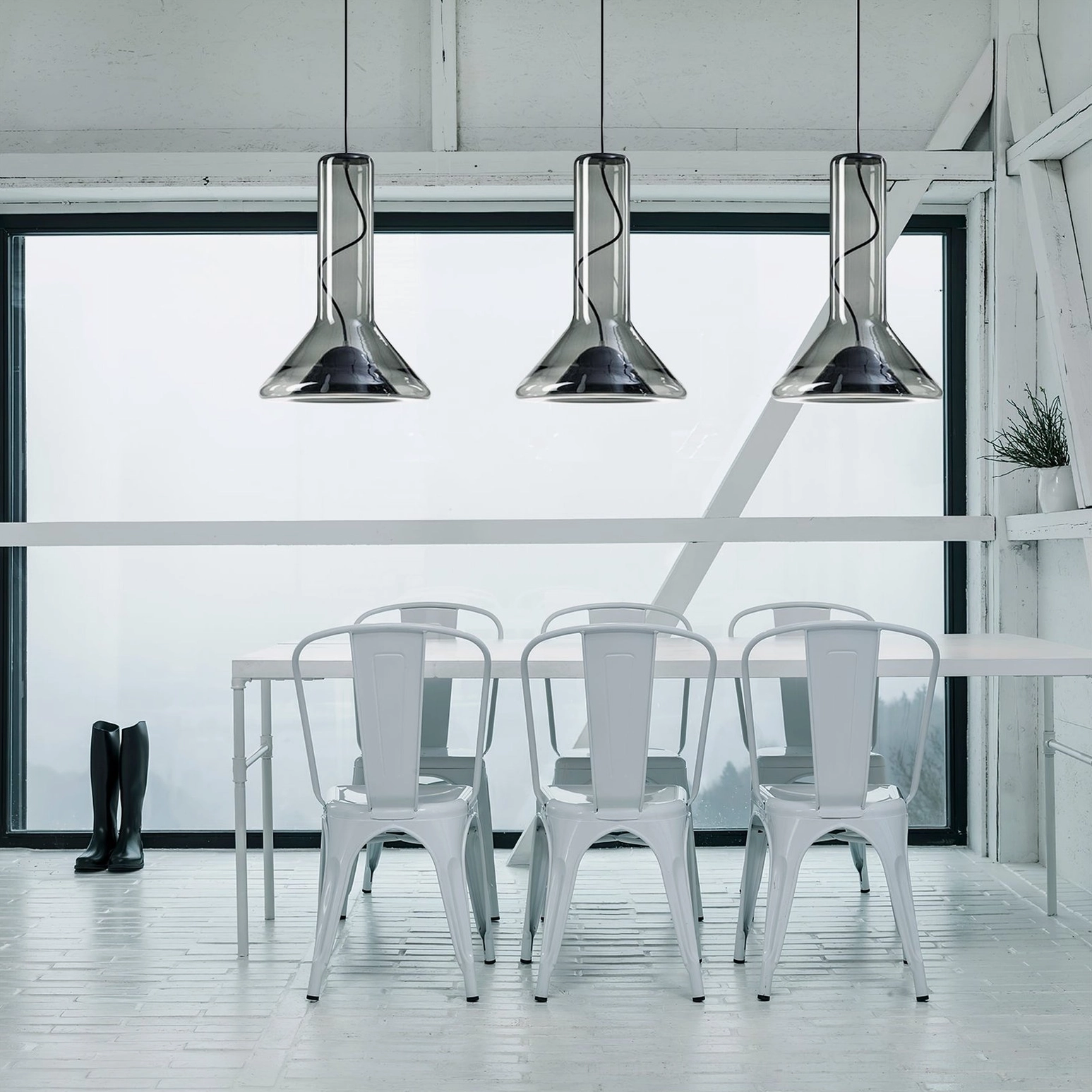 Trio of matching glass whistle pendant lamps in bright minimalist dining room with white furniture