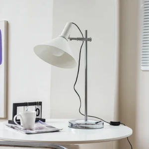 Modern white adjustable desk lamp displayed on home office desk with coffee and magazine