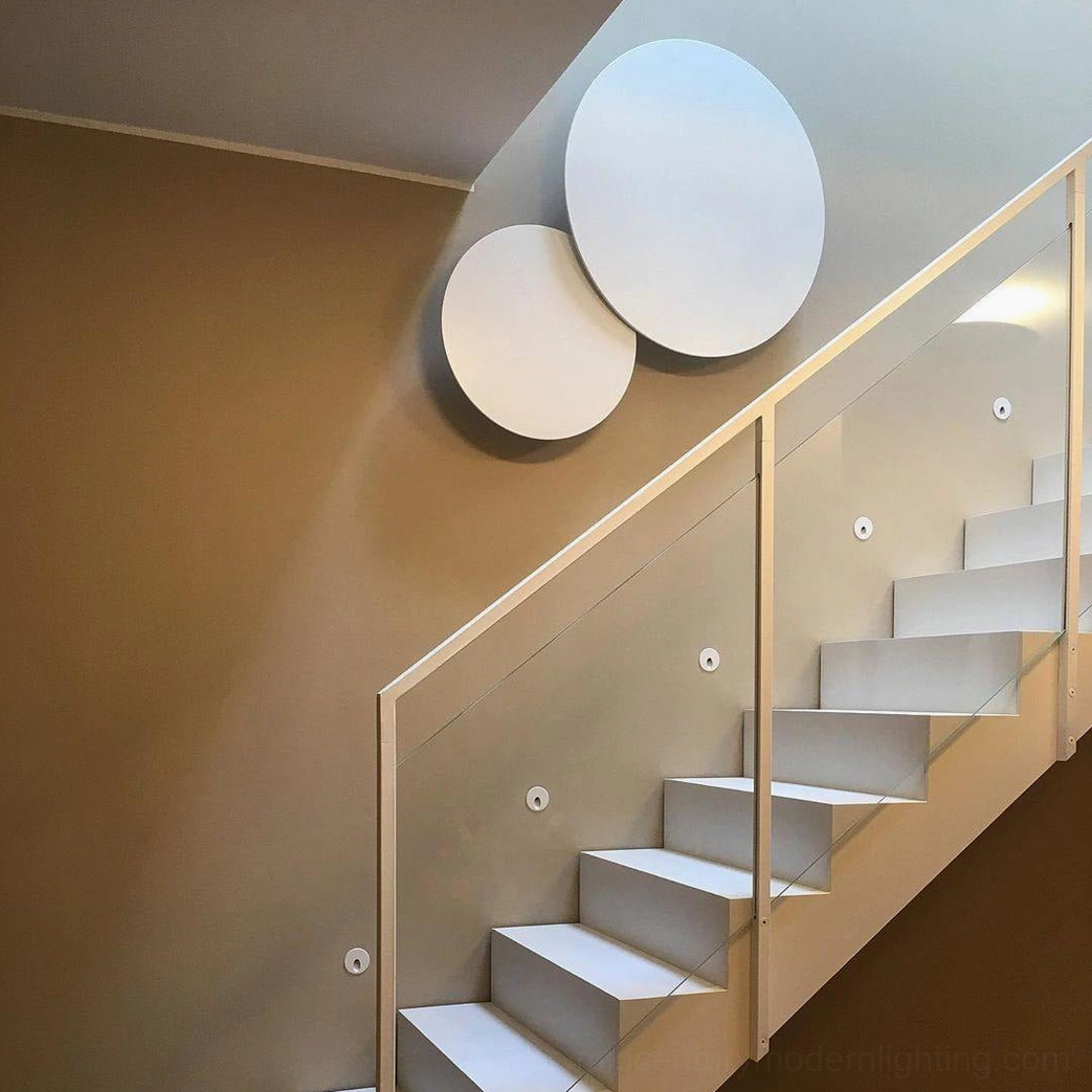 Stacked white geometric disc wall sconce in modern staircase hallway creating sculptural accent lighting in compact space