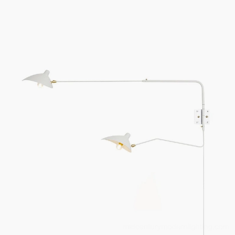 Matte white dual-arm articulated wall sconce installed above luxury headboard
