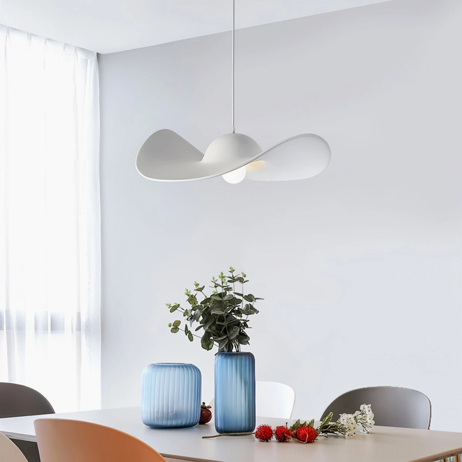 Bright white hat pendant lamp in modern dining room with decorative tableware